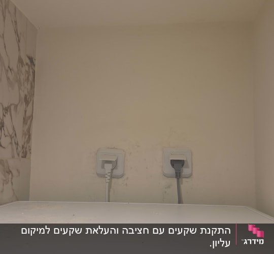 שני שקעים עם תקעים מחוברים מעל מכונת כביסה